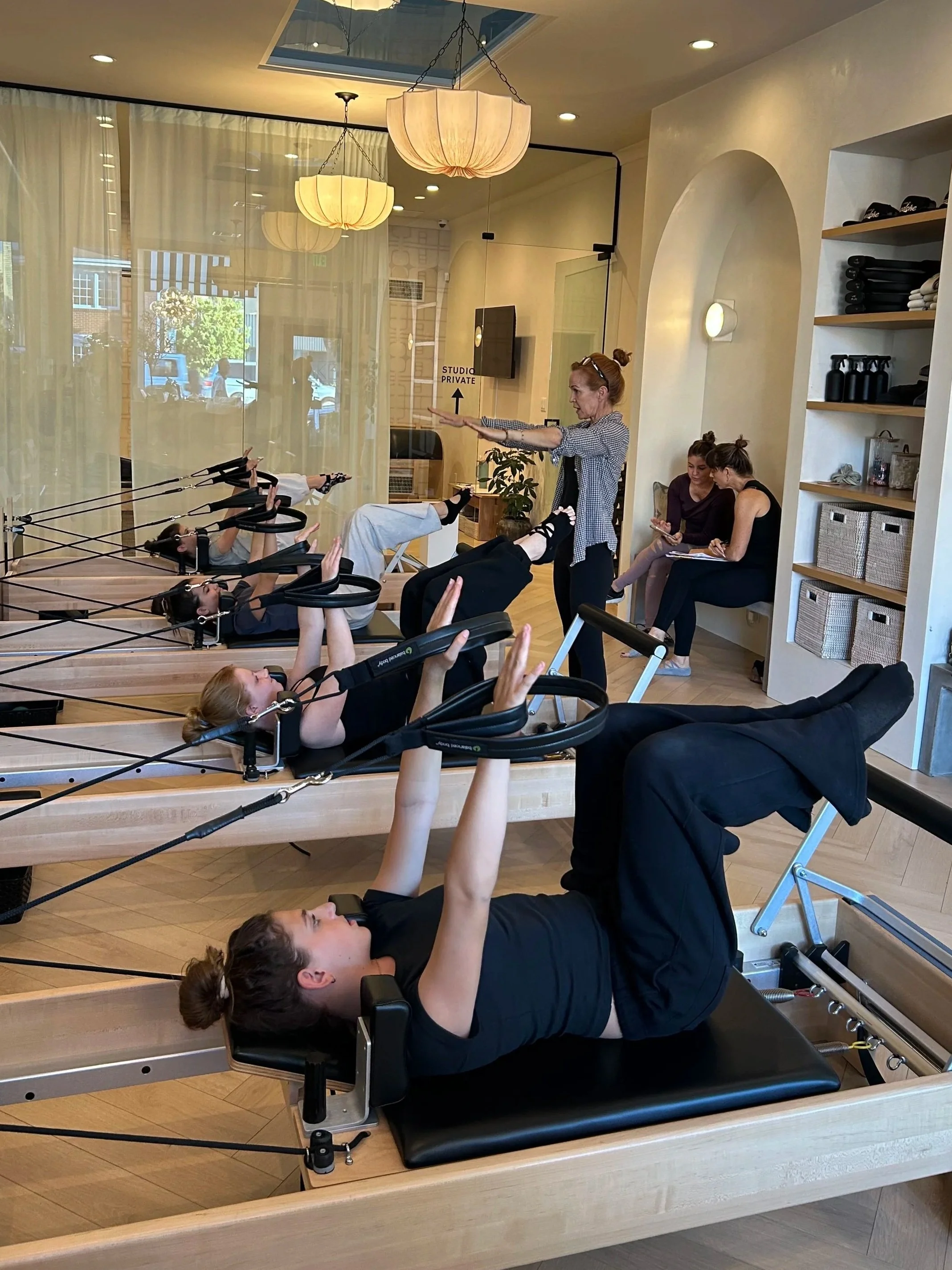 instructor showing students on the pilates machine
