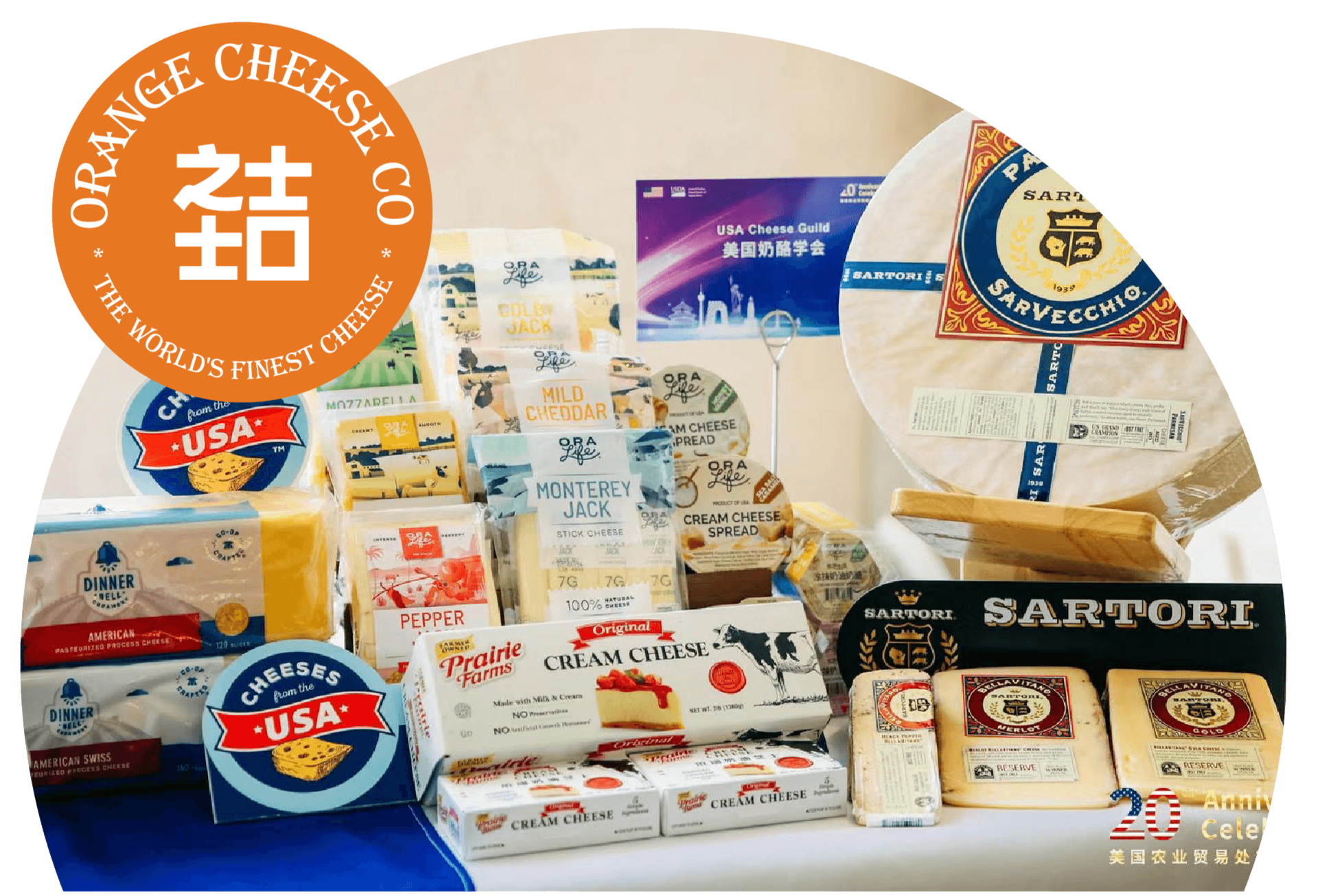 Display of various American cheeses and cheese products, with packaging featuring brand names like Prairie Farms, Sartori, and Ora, arranged on a table for a cheese celebration event.