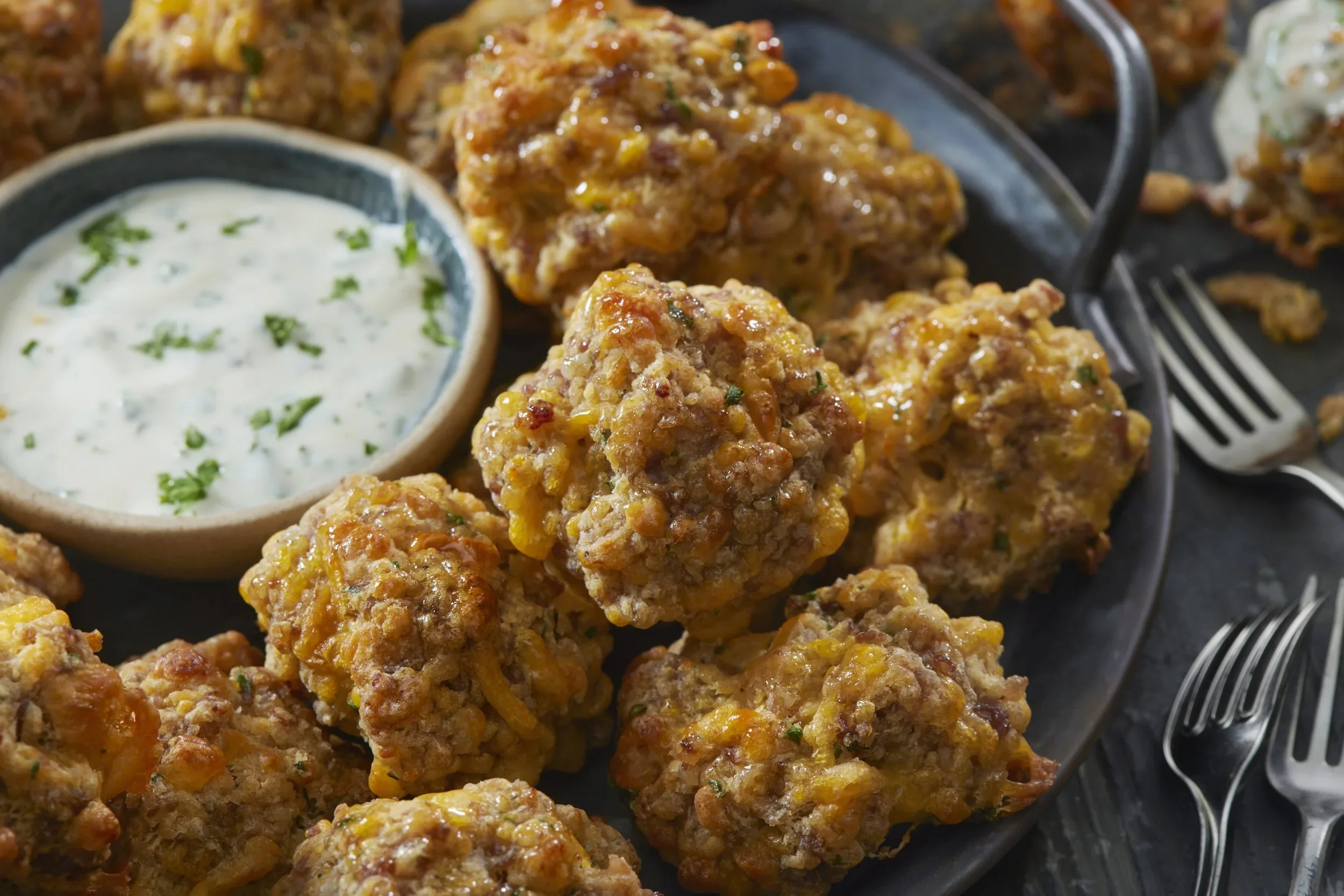 Close-up of fried cauliflower bites with a side of ranch dipping sauce on a gray plate