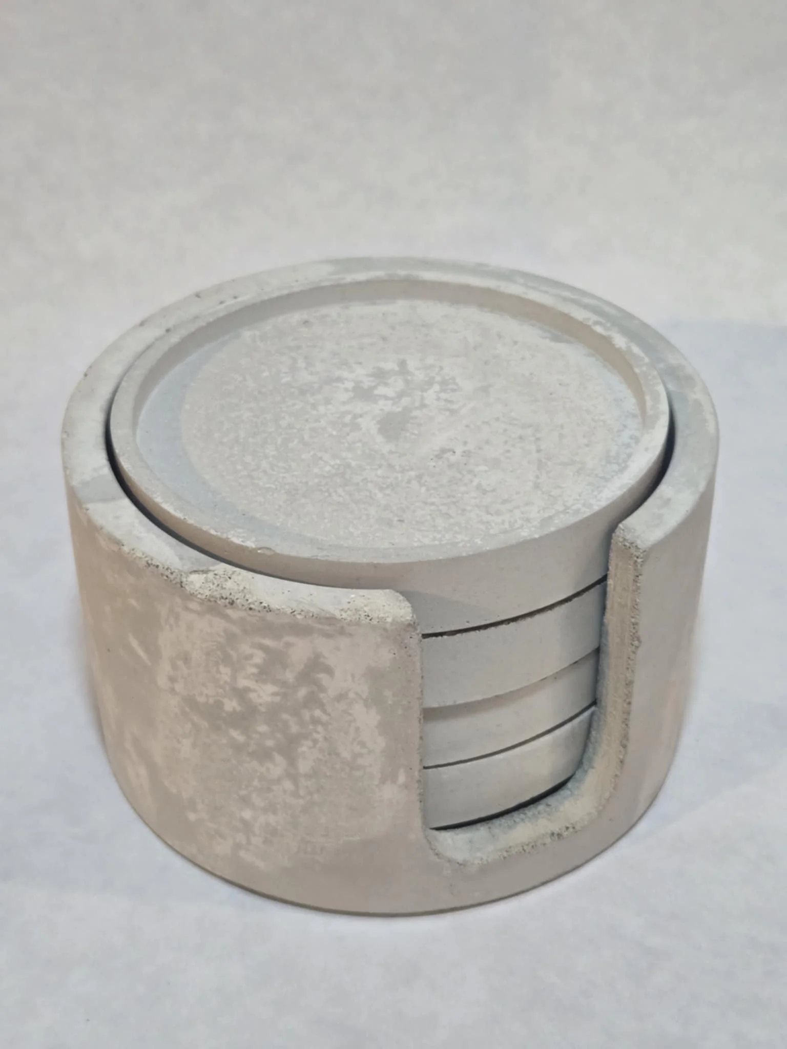 Close-up of a silver, circular, metallic object with a cutout section revealing multiple stacked, curved, thin layers inside.