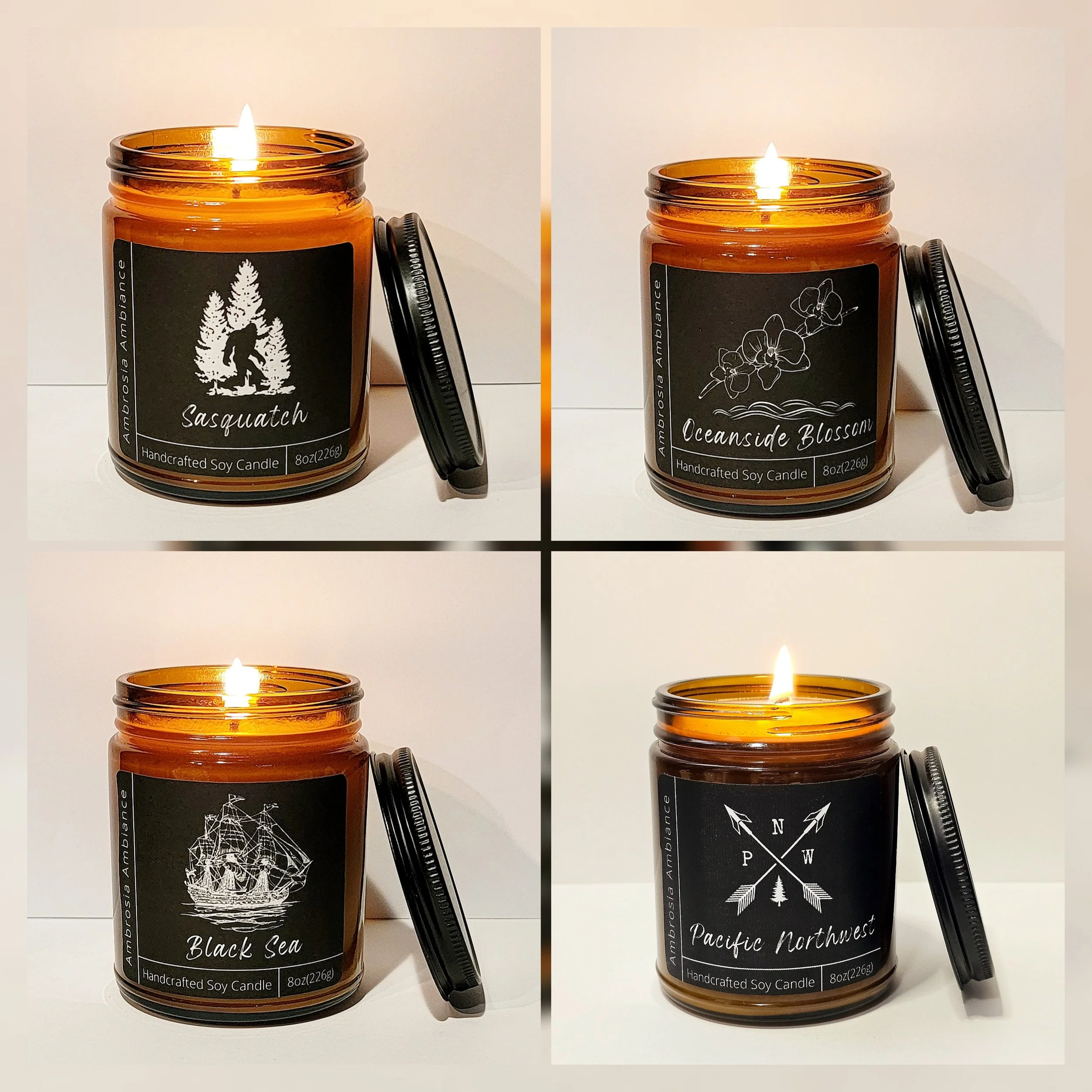 Set of four amber glass candles with black labels and black lids, each lit and featuring different designs and names: Sasquatch, Oceanside Blossom, Black Sea, and Pacific Northwest.