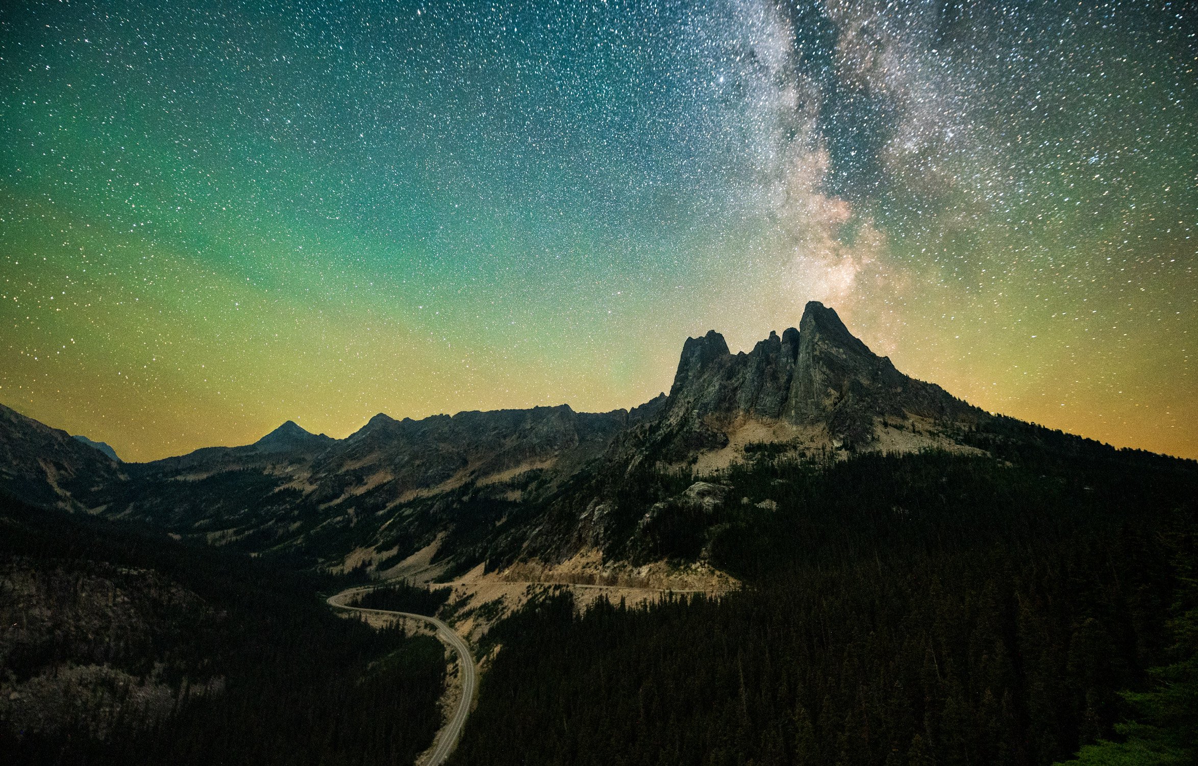 Night sky over mountain landscape with visible the Milky Way galaxy and northern lights