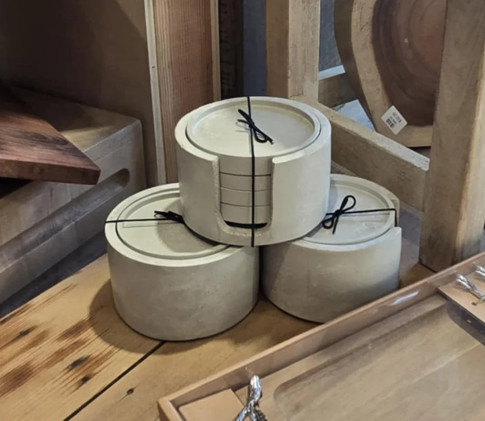 Three stacked beige ceramic bowls secured with black zip ties in a woodworking or hardware store.