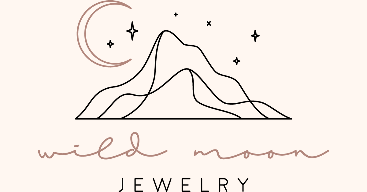 Line drawing of mountains with stars and a crescent moon above and the words 'wild moon jewelry' scribbled below.