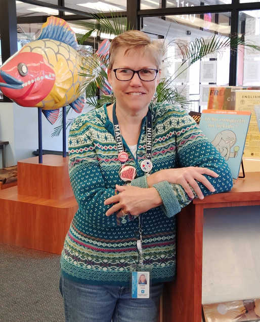 A part-time librarian at Baltimore County Public Libraries poses for photo while wearing a "machinists" lanyard on her work ID card along with IAM Union and BCPL United buttons.