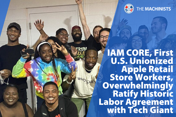 Several workers at Apple Towson celebrating in from of a white brick wall. With text that reads "IAM CORE, First U.S.