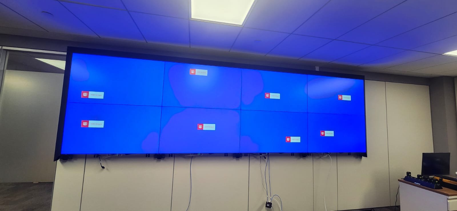 Large flat-screen display wall with multiple screens showing a blue background with error messages.
