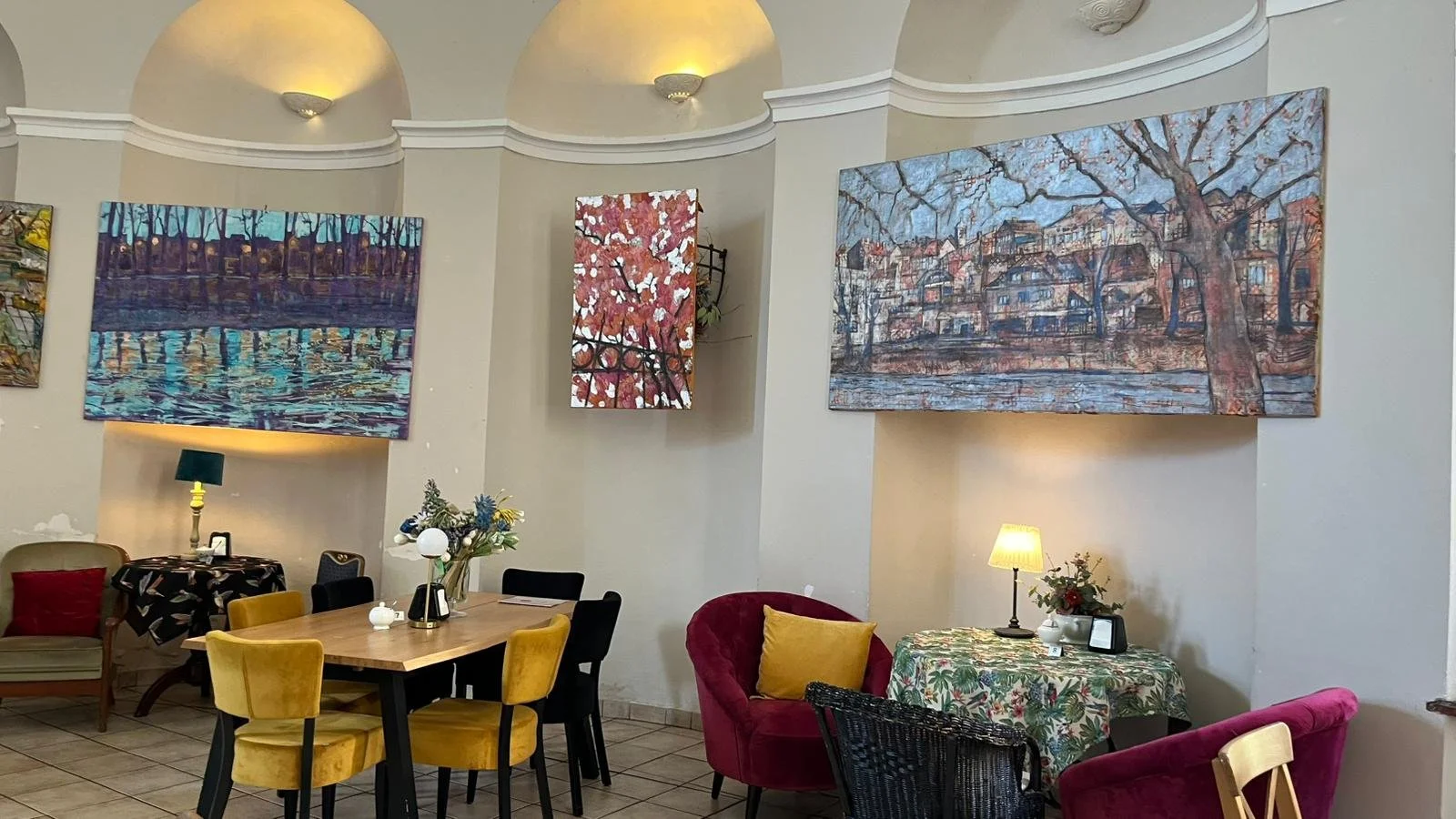 Close-up of three landscape paintings, during the exhibition preparations, showing the view of Cieszyn in the interior space.