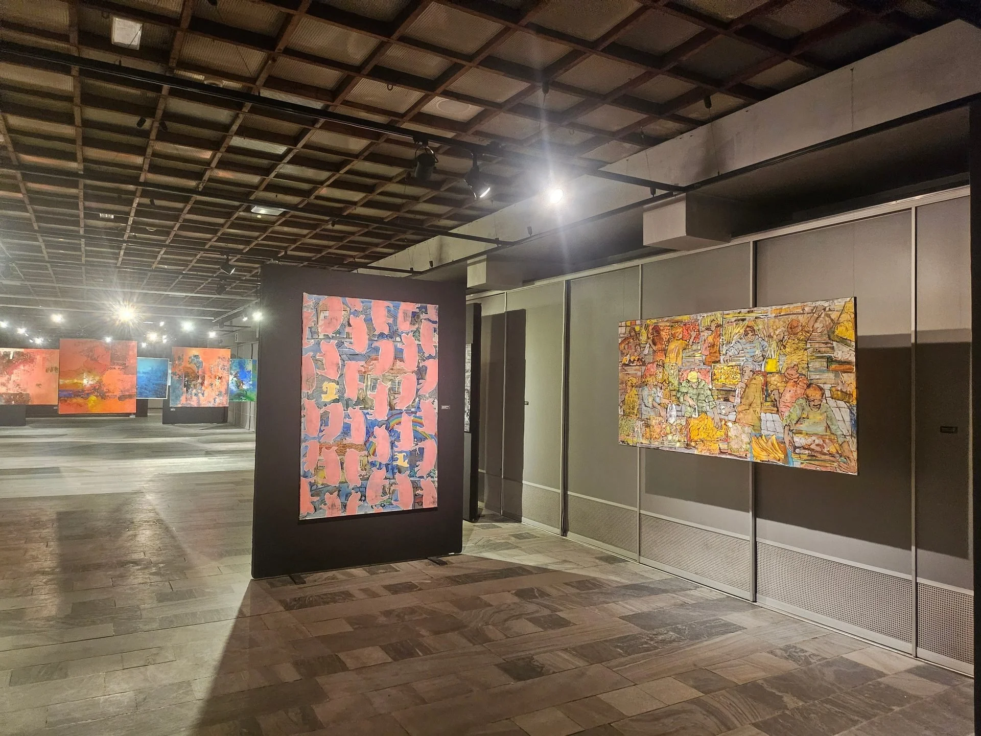 Paintings in different style presented during exhibition inside gallery