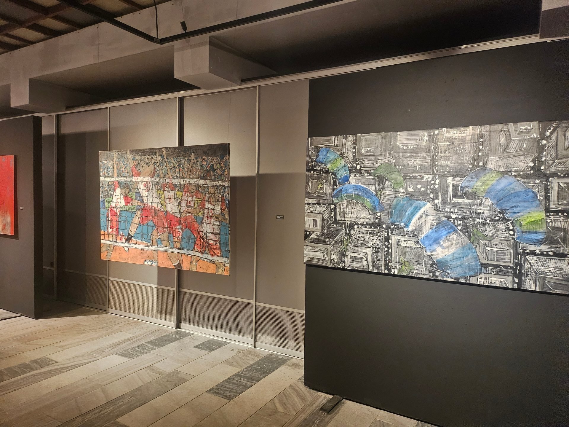 Figurative contemporary paintings hanging on a gallery wall during exhibition.