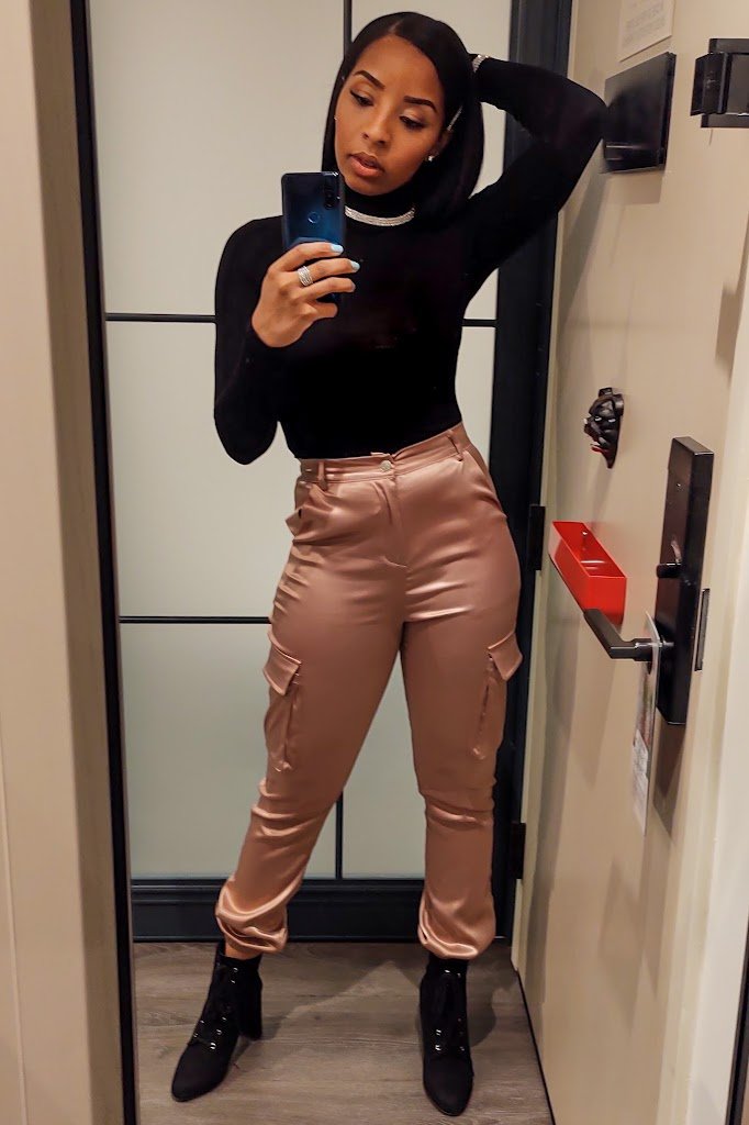 woman in black turtleneck, pink cargo pants and black booties