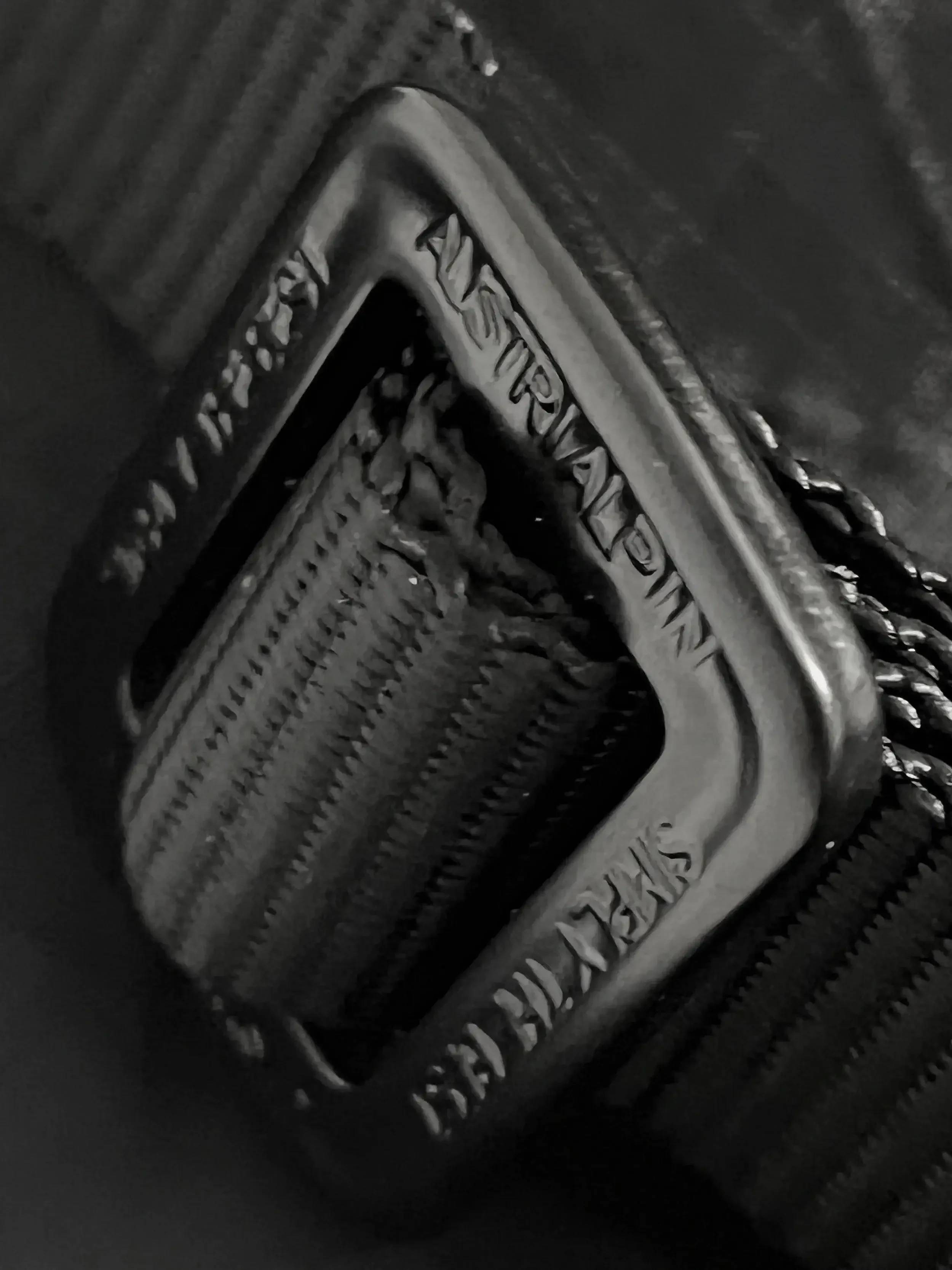 Close-up of a metallic gear with engraved text 'PERFECT' and 'BRASS' on its surface.