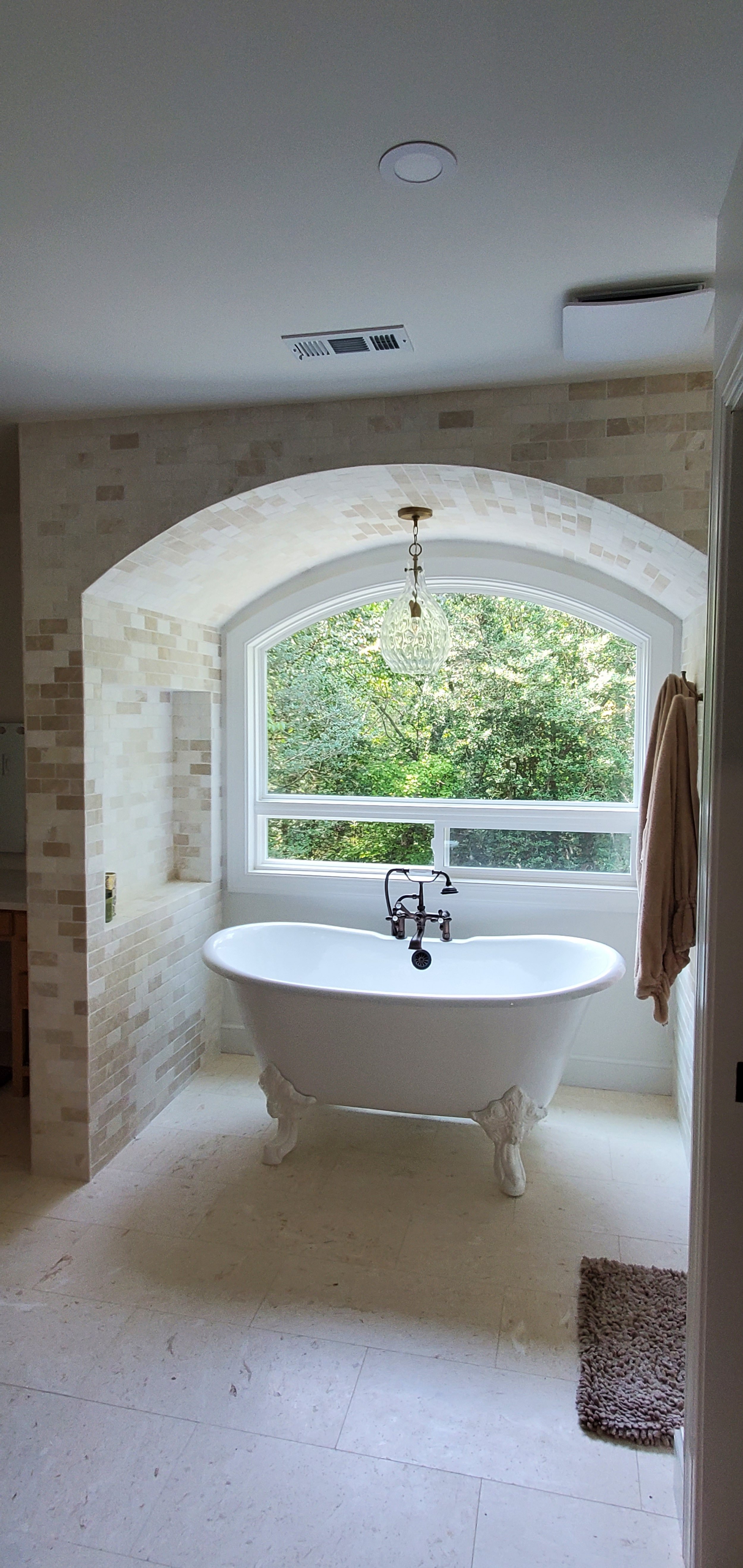 Jewel Box Homes - near Williamsburg VA -  European bathroom with a clawfoot bathtub positioned in front of a large arched window hanging light fixture.