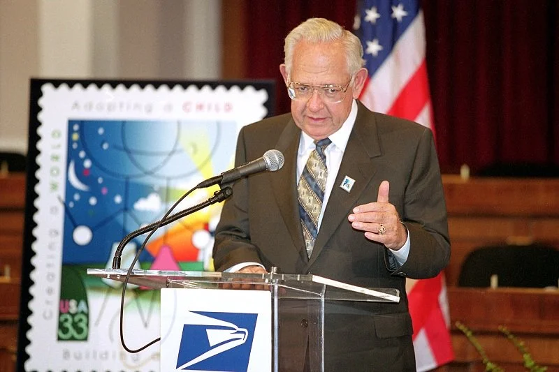 Dave Thomas with US Commemorative stamp celebrating adoption