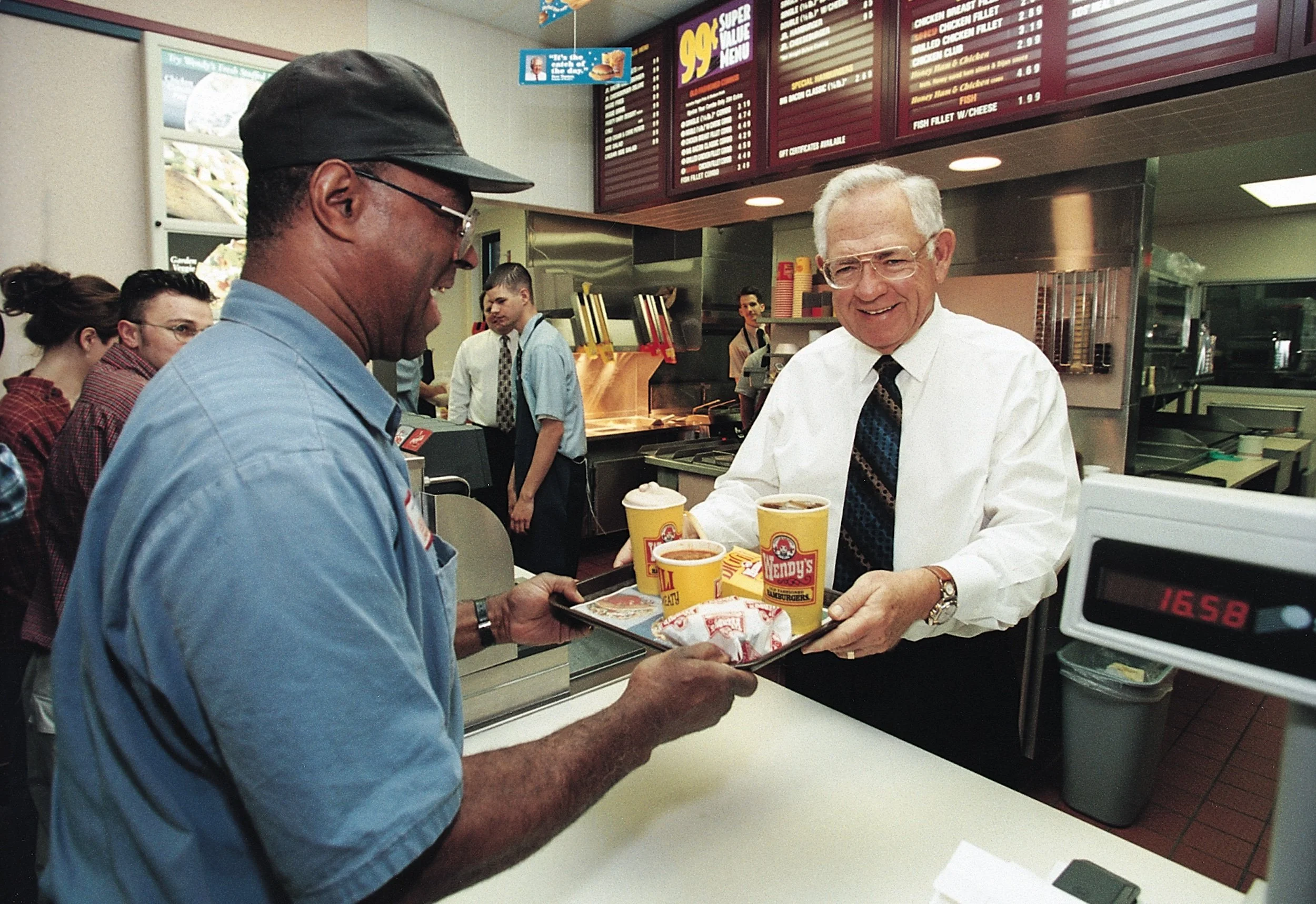 Dave Thomas handing a tray of food to a customer