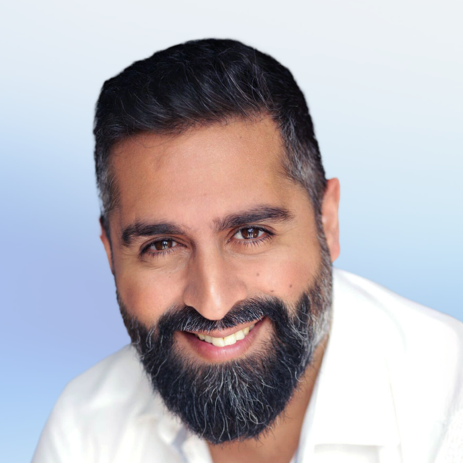 Close-up of a smiling man with dark hair and a beard, wearing a white shirt, against a light blue background.