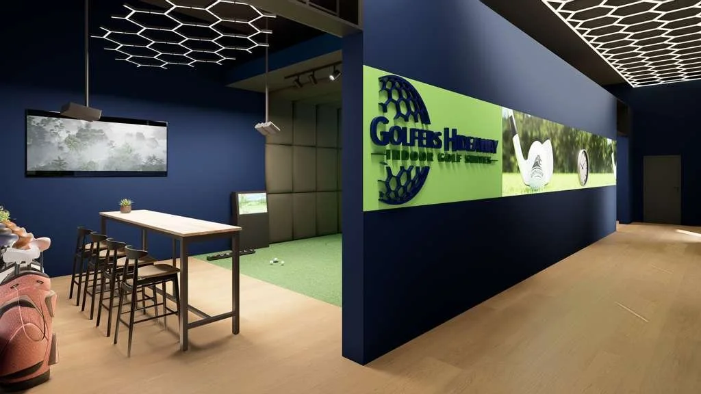 Indoor golf simulator lounge with a seating area and a sign that reads 'Golf Hub Academy Indoor Golf Stream' on a bright green wall.