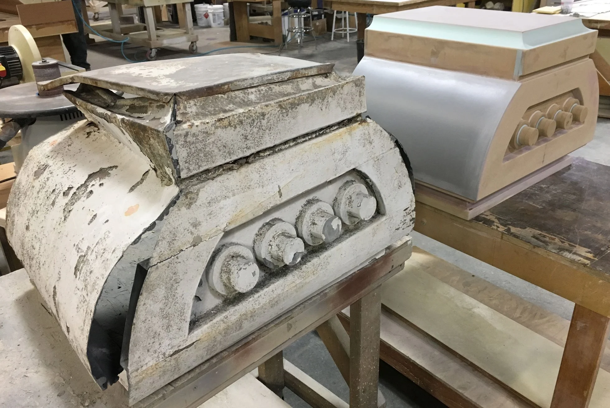 A historic sheet metal roof cap next to a newly created model in the ACI shop. 