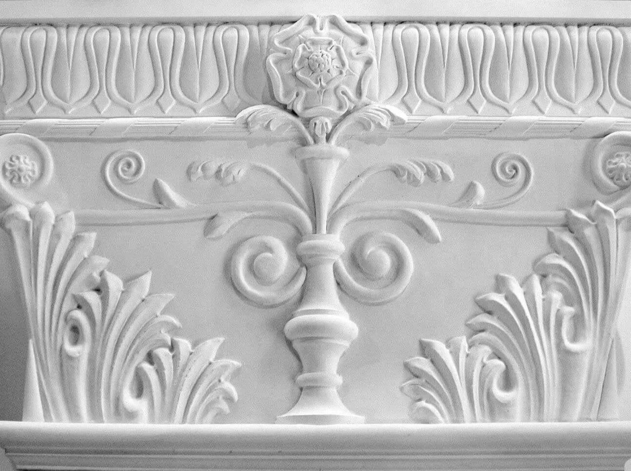 Decorative  plaster pilaster capital with floral and scroll motifs.