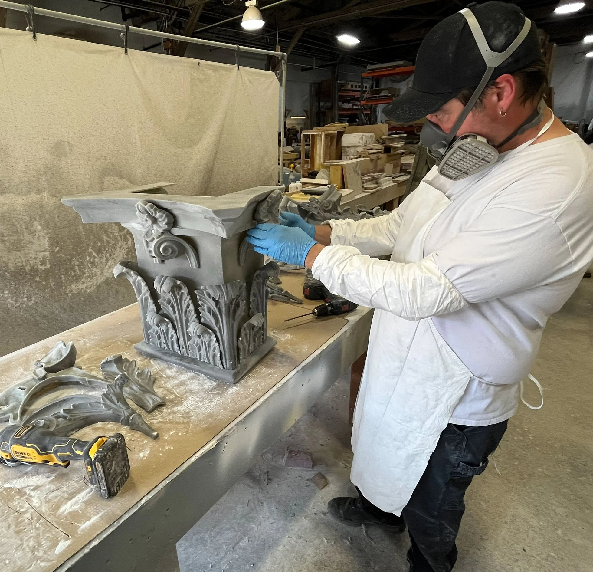 ACI Studios crew working on an ornate architectural column capital, assembling parts after molding. 