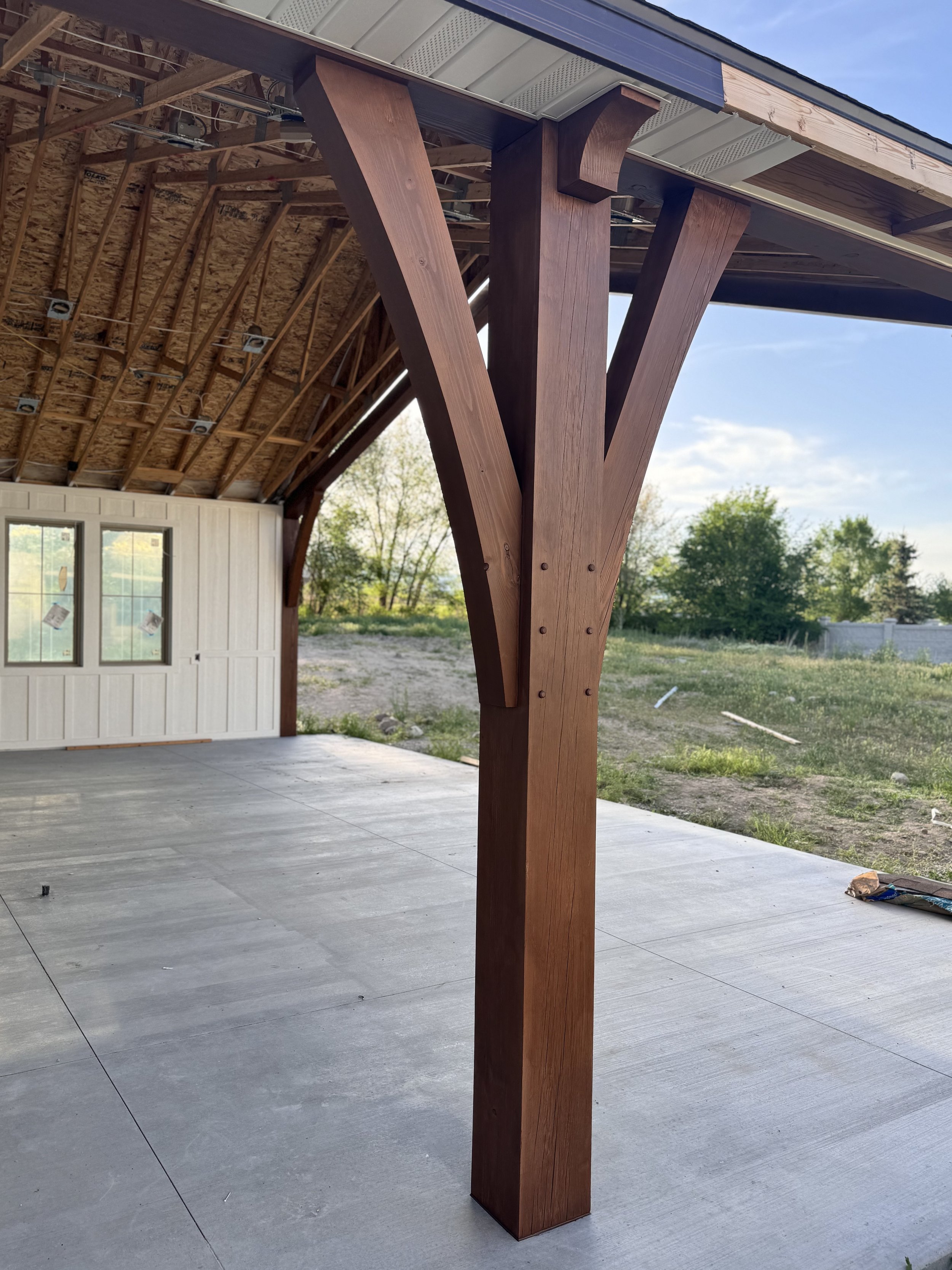 Timber beam and post attached to backyard scissor pergola patio install. 