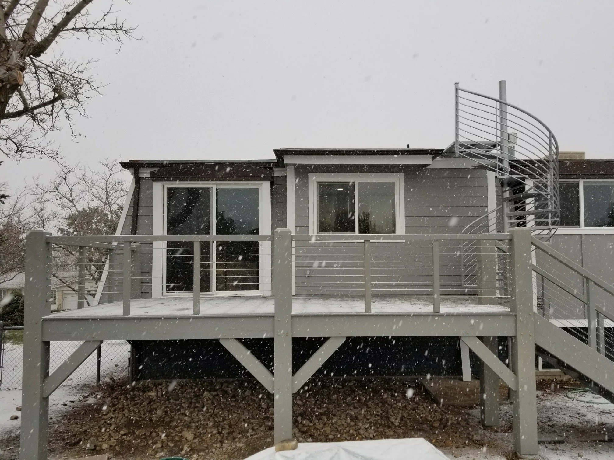 A back porch with a staircase leading to a deck using our timber frames and joinery as the foundation. 