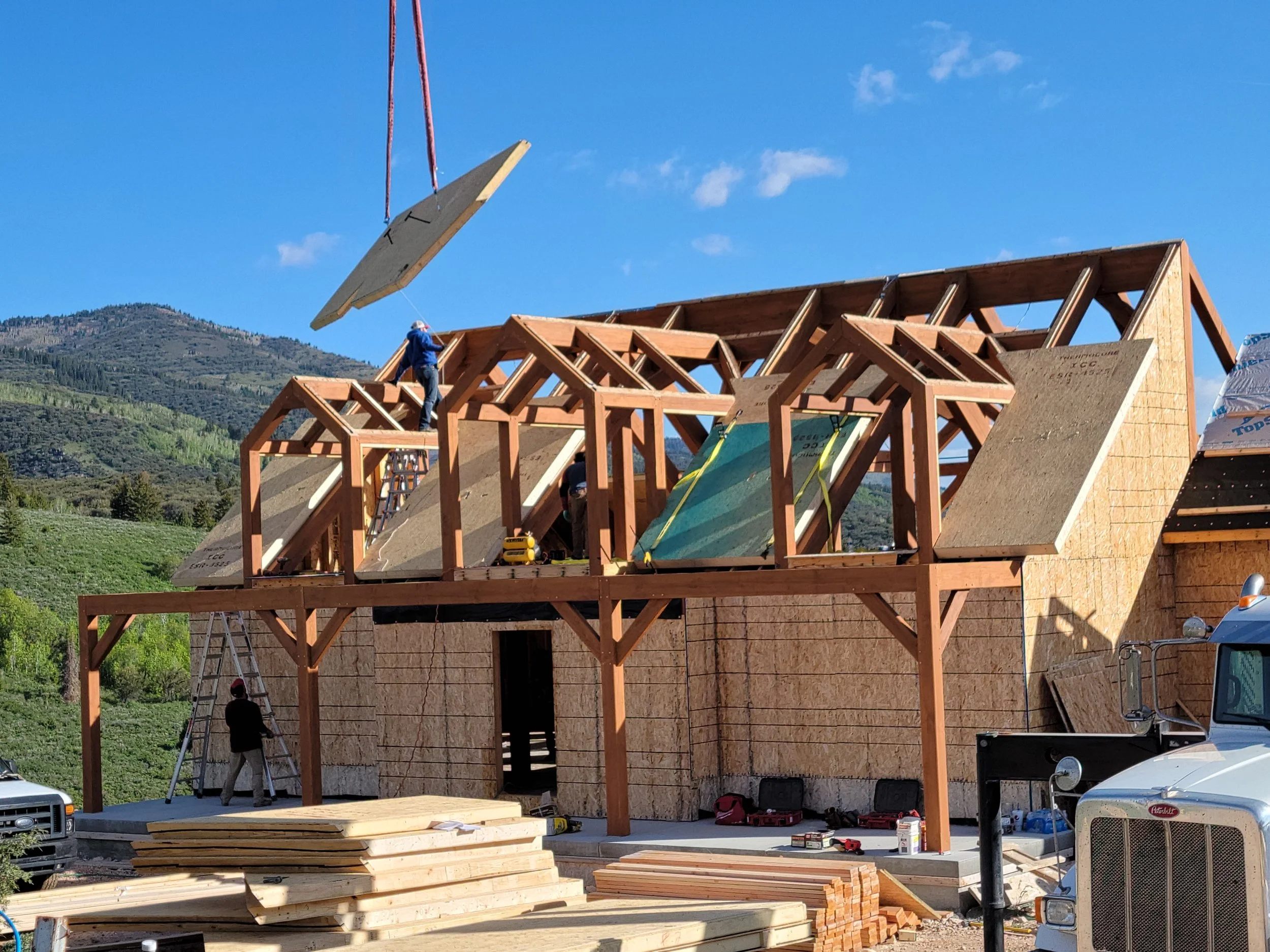 Our team installing timber frames on a house with a detailed roof design. 
