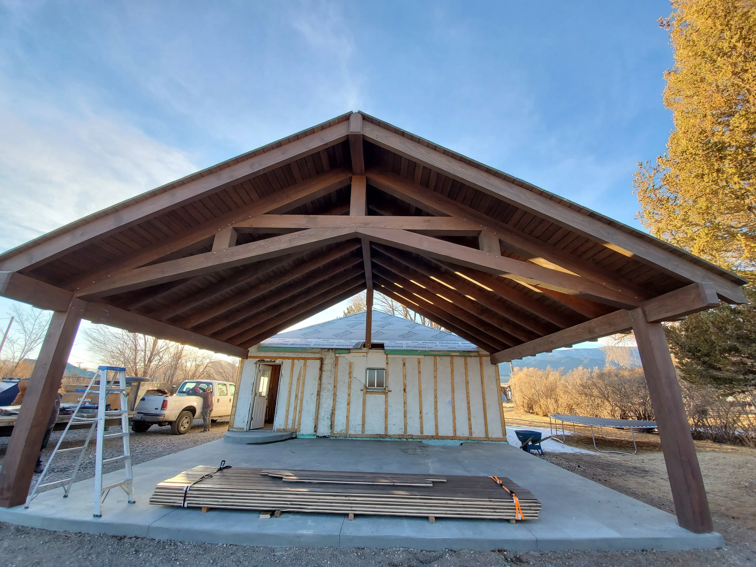 An outdoor scissor pergola in process of being installed. 