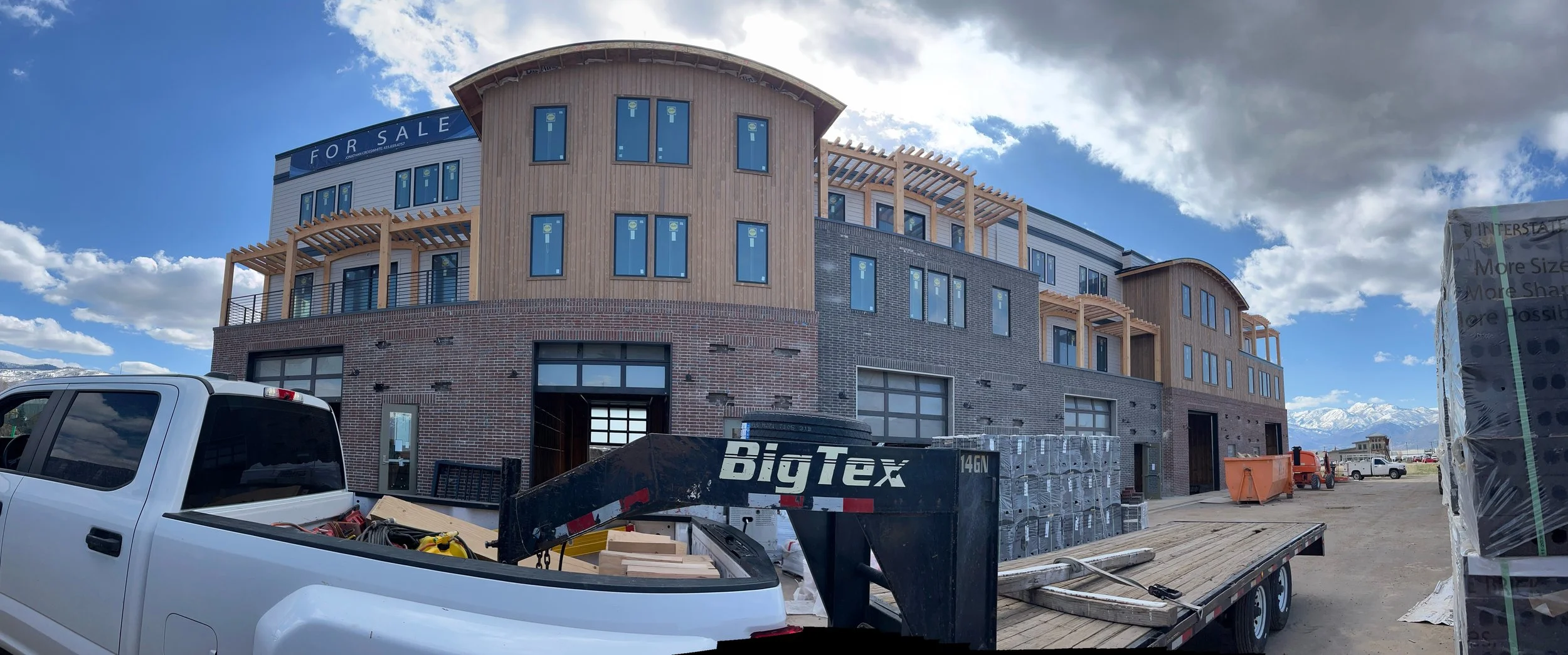 Construction site of a multi-story building in progress, featuring our timber frame pergolas, for this commercial project. 