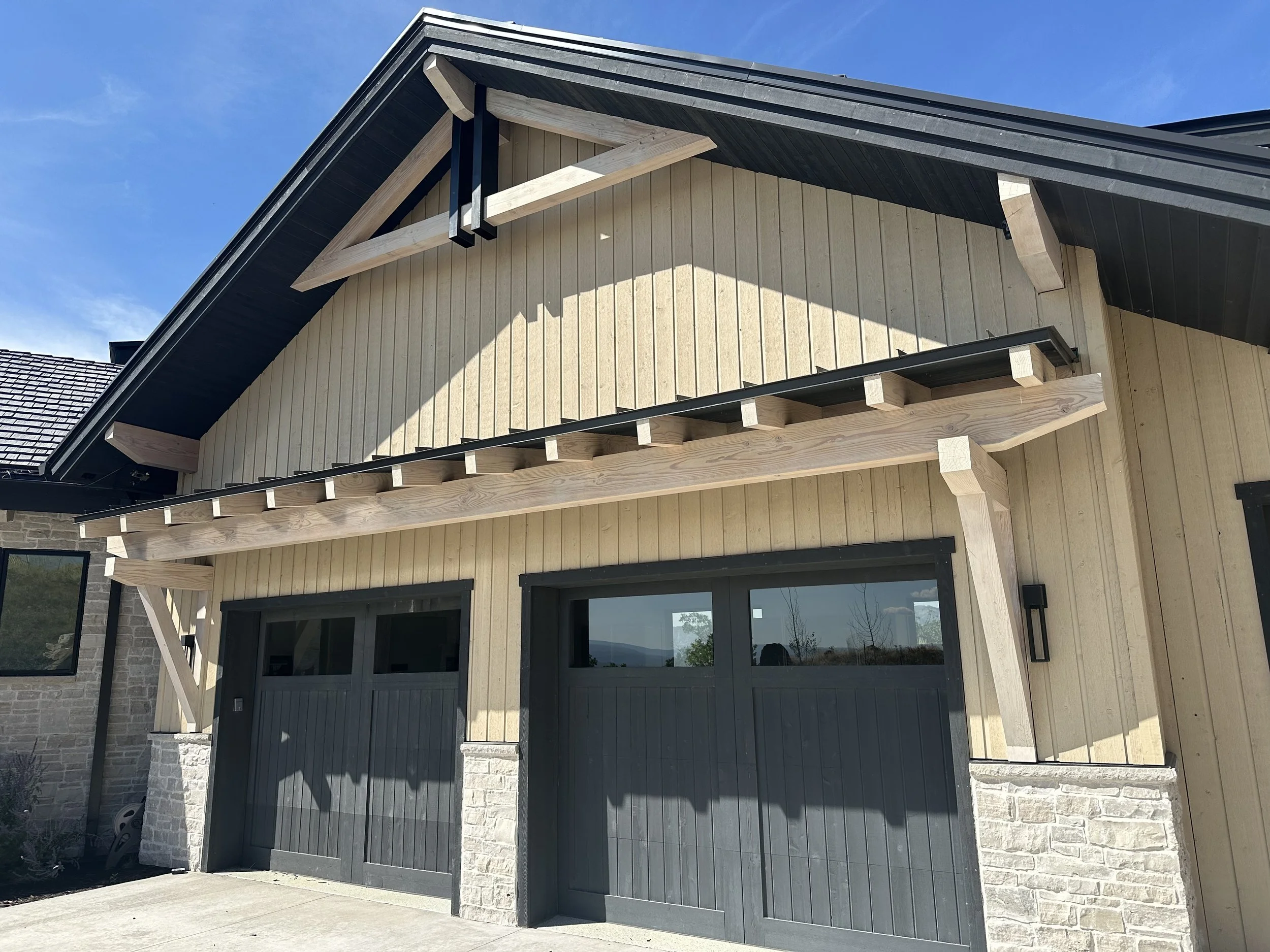 Exterior of a modern house with our exposed timber truss installed over the two-car garage.