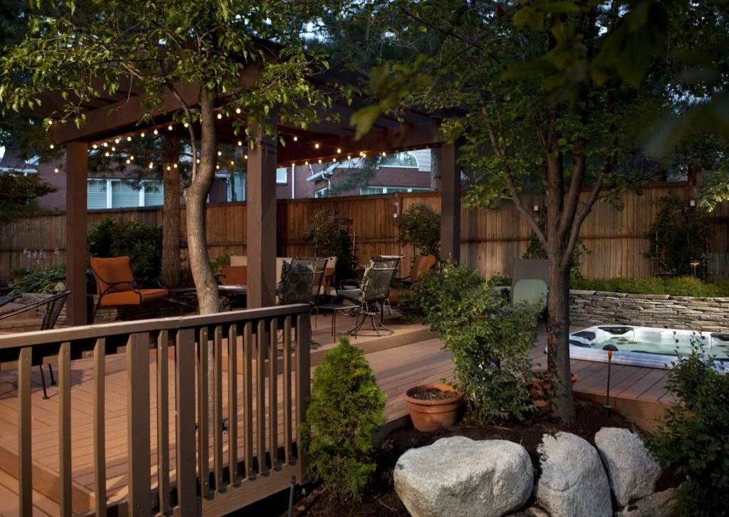 A backyard patio pergola with a covered seating area. 