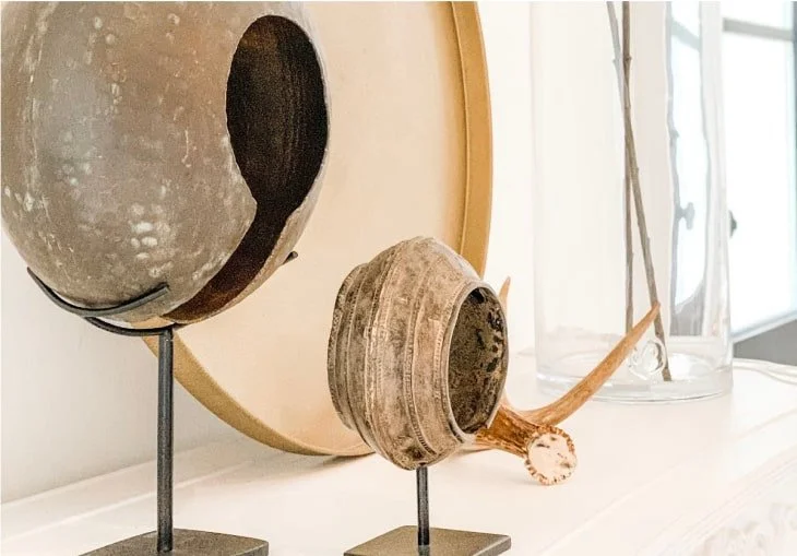 Decorative artifacts including a guiro, a clay vessel, and a glass vase on a shelf.