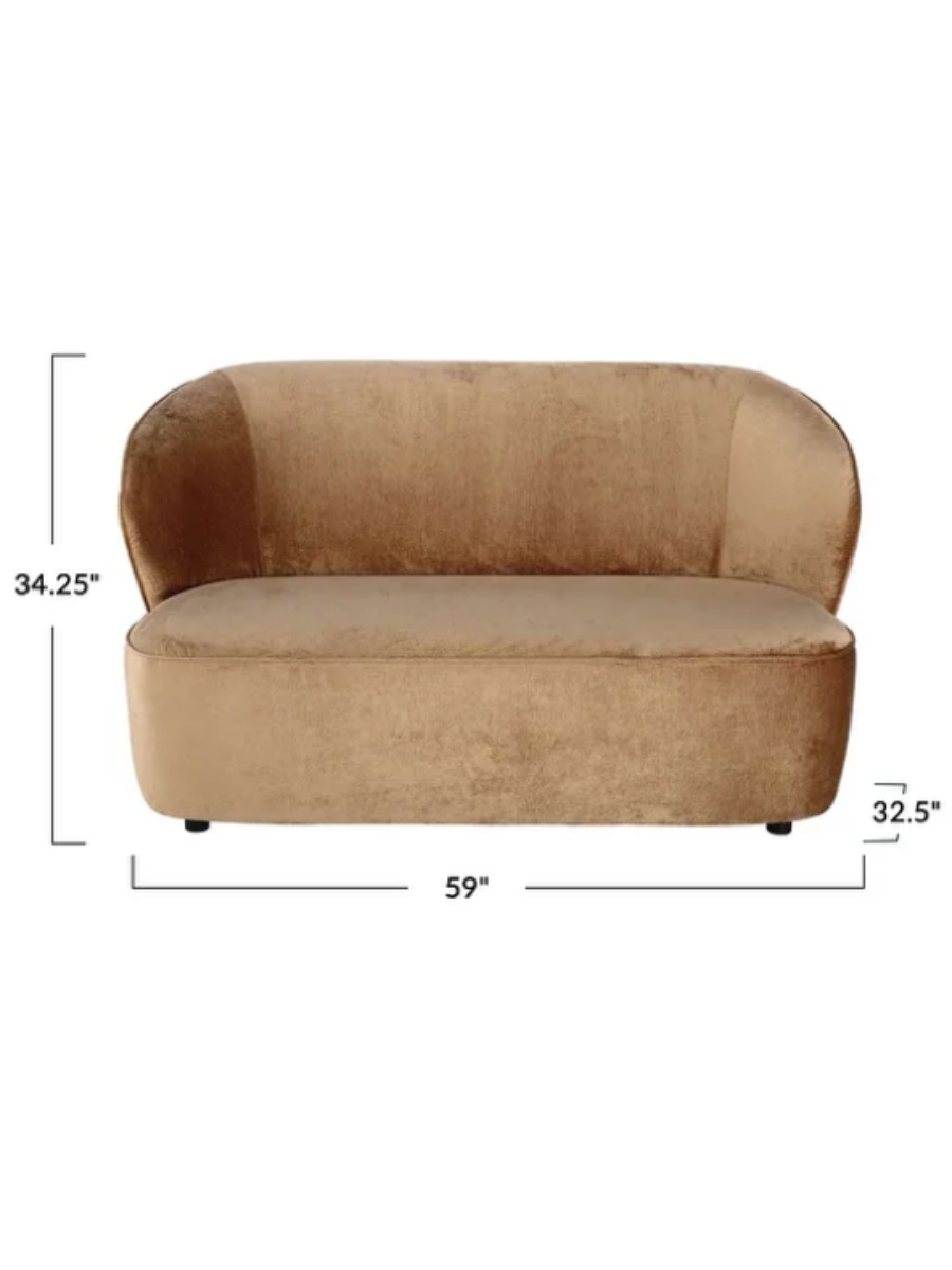 Modern camel brown velvet loveseat featuring a curved backrest, rounded arms, a plush bench seat, and a sculptural low-profile silhouette.