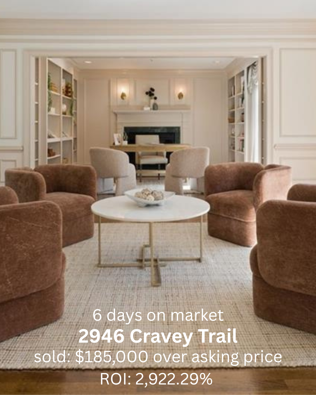 Living room with beige walls, built-in bookshelves, a white fireplace, a round coffee table, six brown upholstered chairs, a wooden dining table, and two beige armchairs in front of the fireplace.