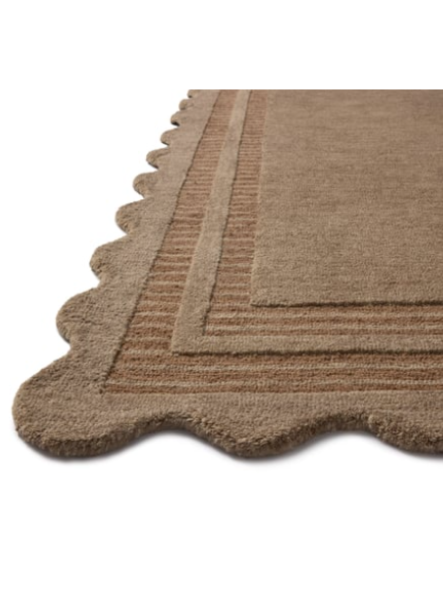 Hand-tufted wool area rug with a playful scalloped edge and lower-pile, striped border for a touch of structure. With mocha brown and rust/clay colors along the fun border. (7’9”x 9’9”)
