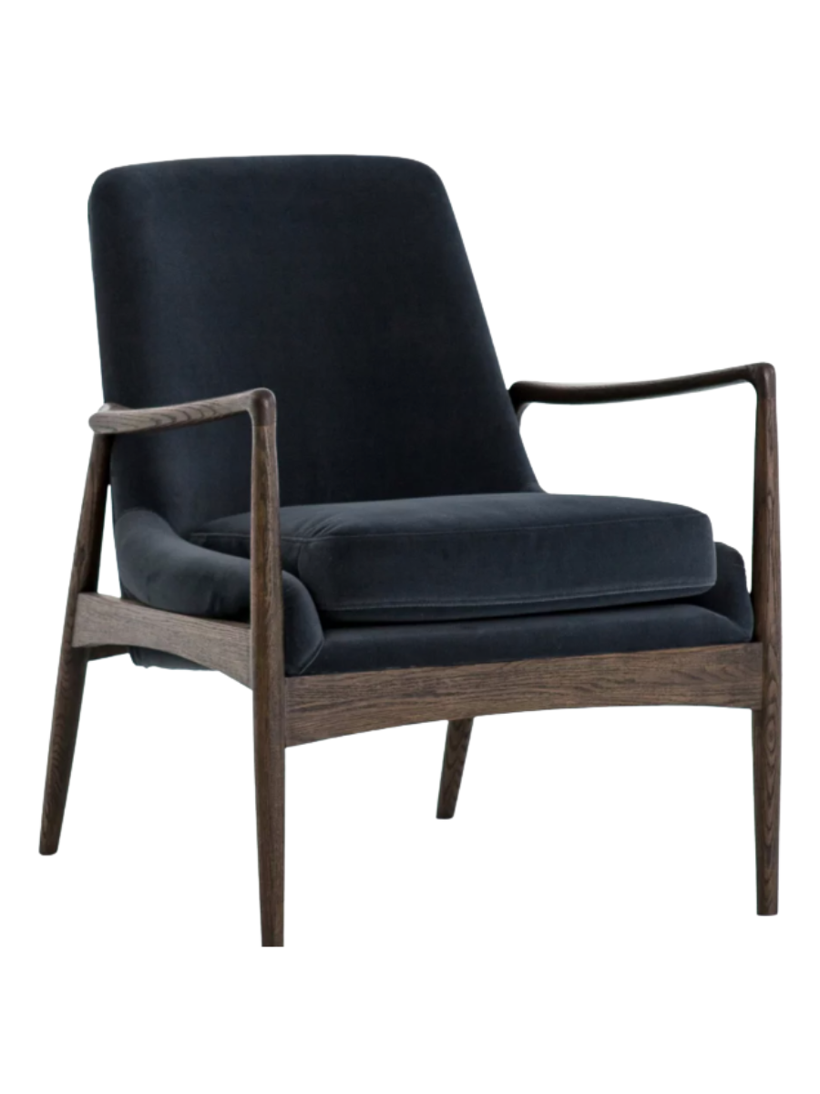 Mid-century modern accent chair upholstered in dark navy blue velvet with a tall backrest, plush seat cushion, and exposed dark wood frame with slender arms and tapered legs.