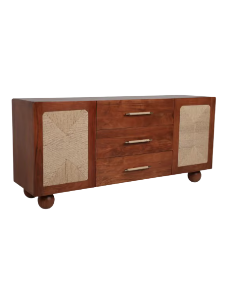 Mid-century modern wood sideboard in a warm reddish-brown finish, featuring three central drawers with brass handles, two cabinet doors with woven beige panels, and rounded ball feet.