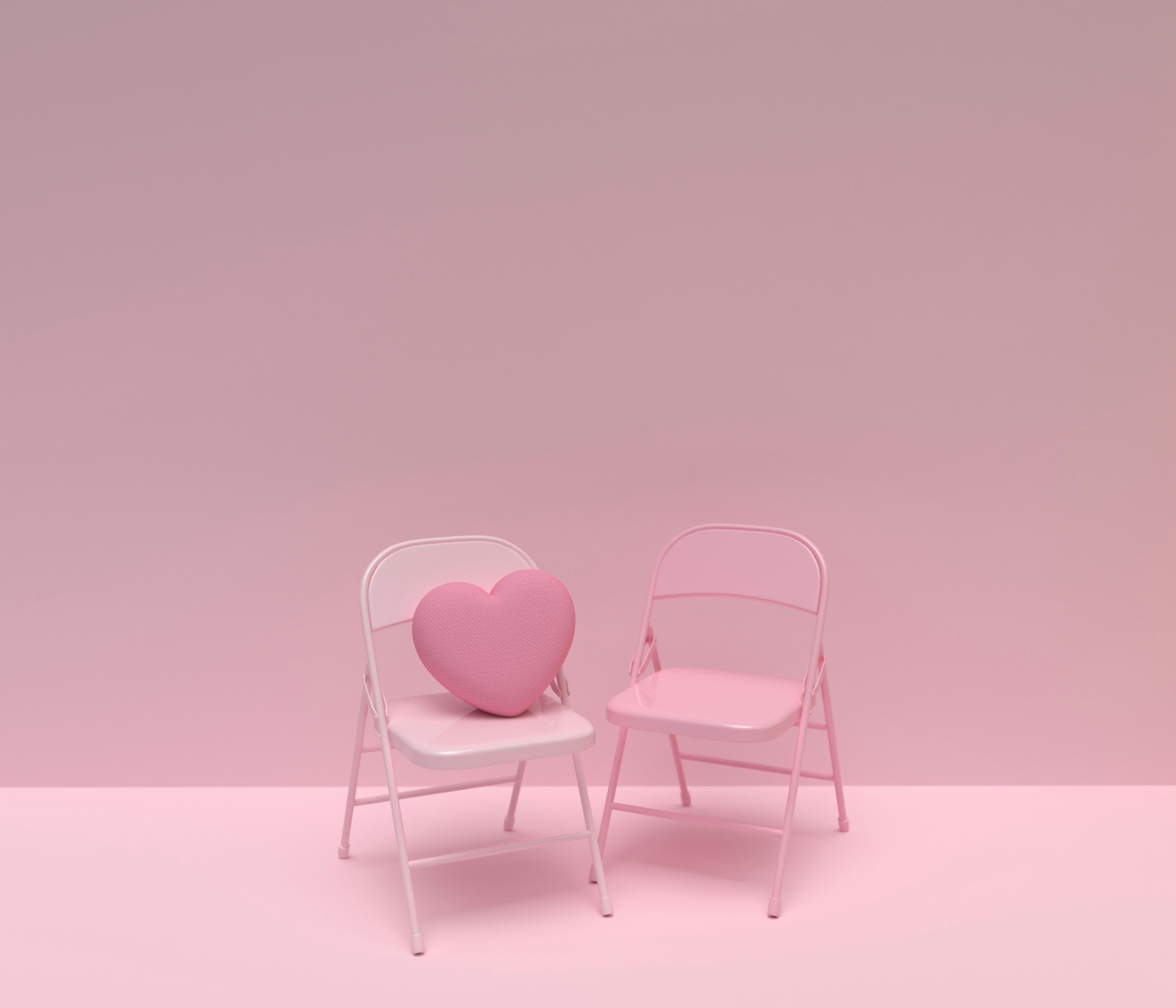 Two pink chairs adorned with a heart-shaped cushion, creating a cozy and inviting seating area.