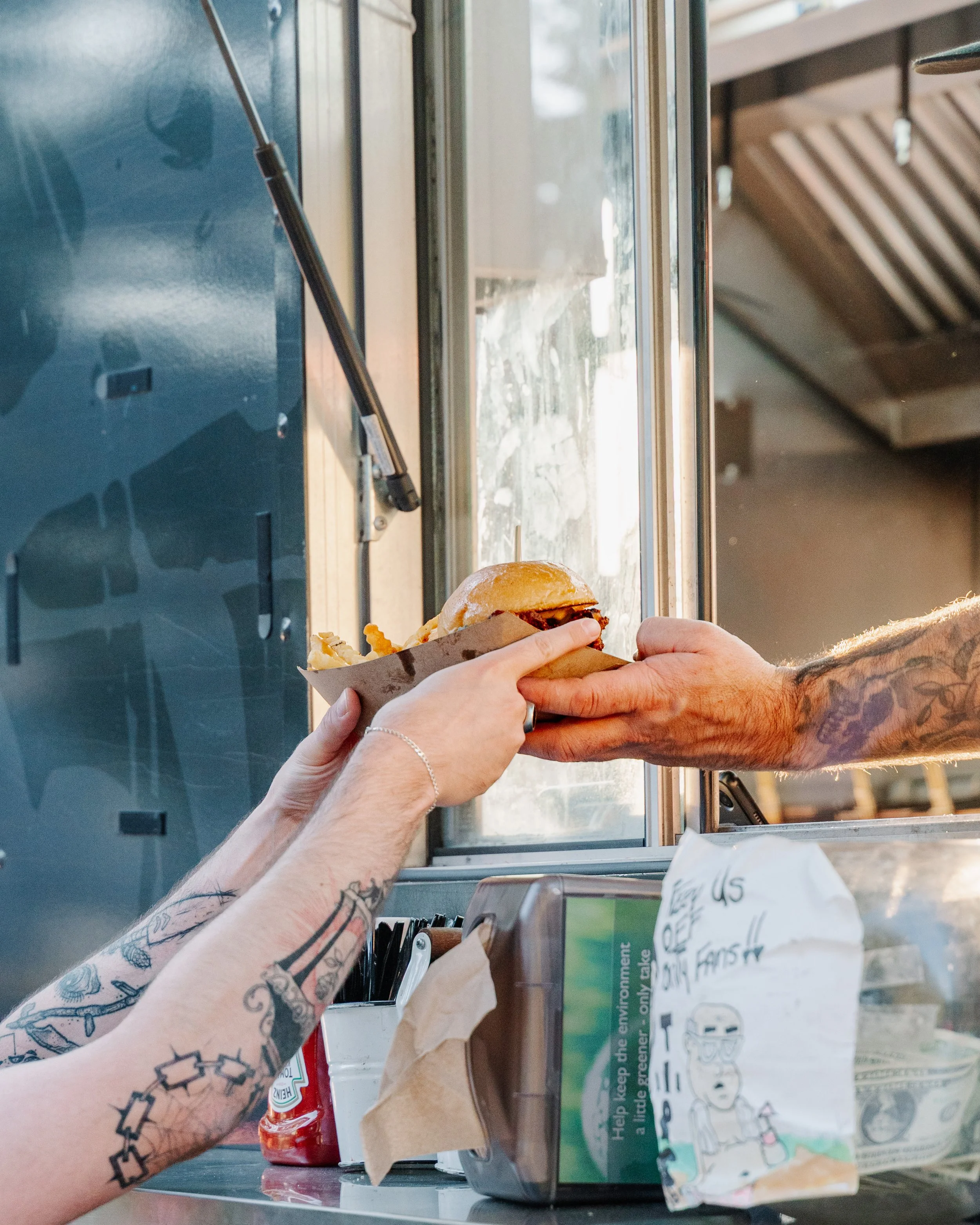 Customer grabbing food from food truck employee