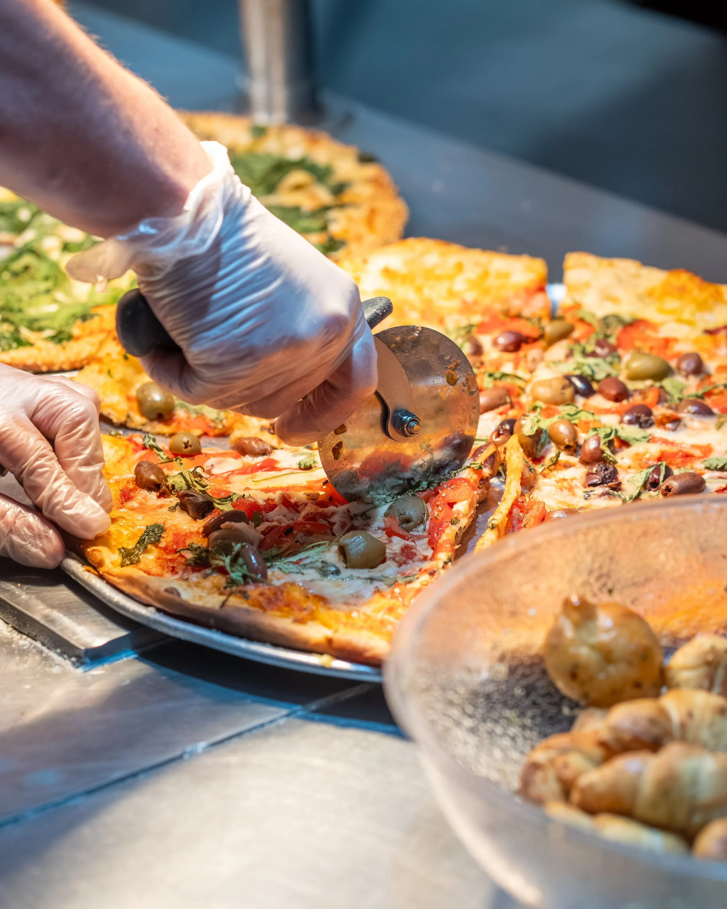 500 Degrees Employee Cutting Pizza