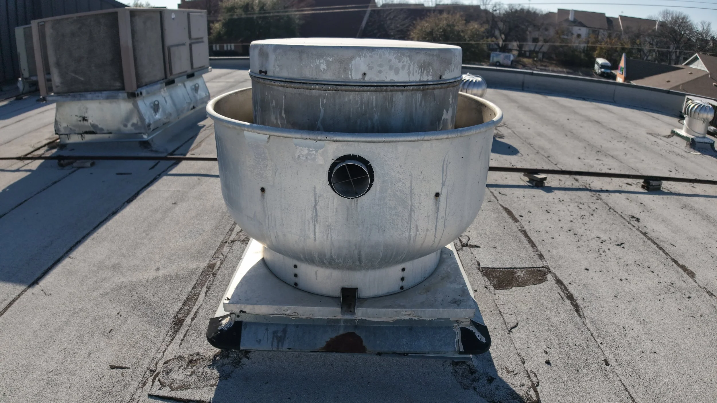 Rooftop ventilation fan on flat roof with surrounding HVAC units