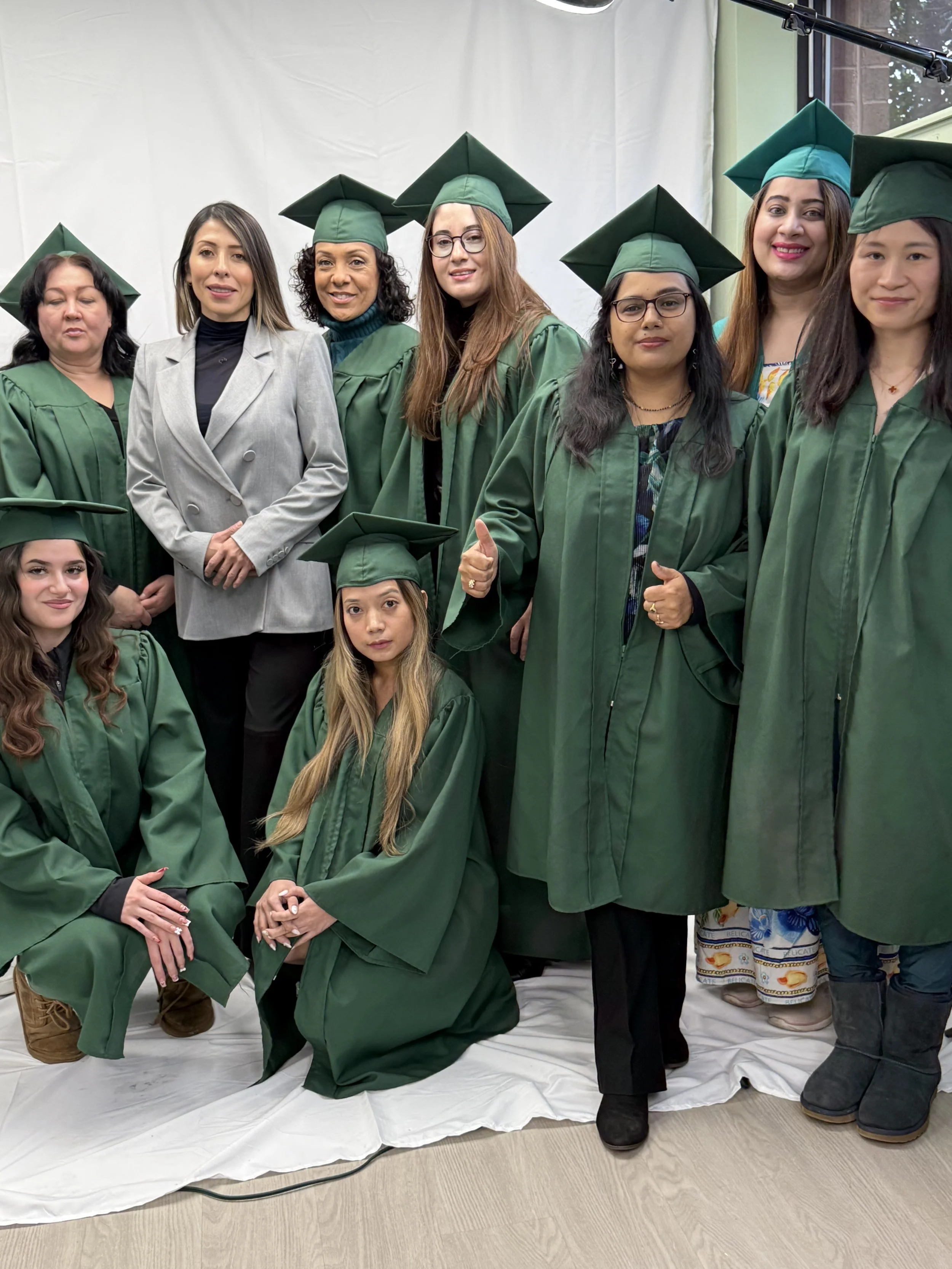 Graduation ceremony for esthetics and beauty school students in green caps and gowns