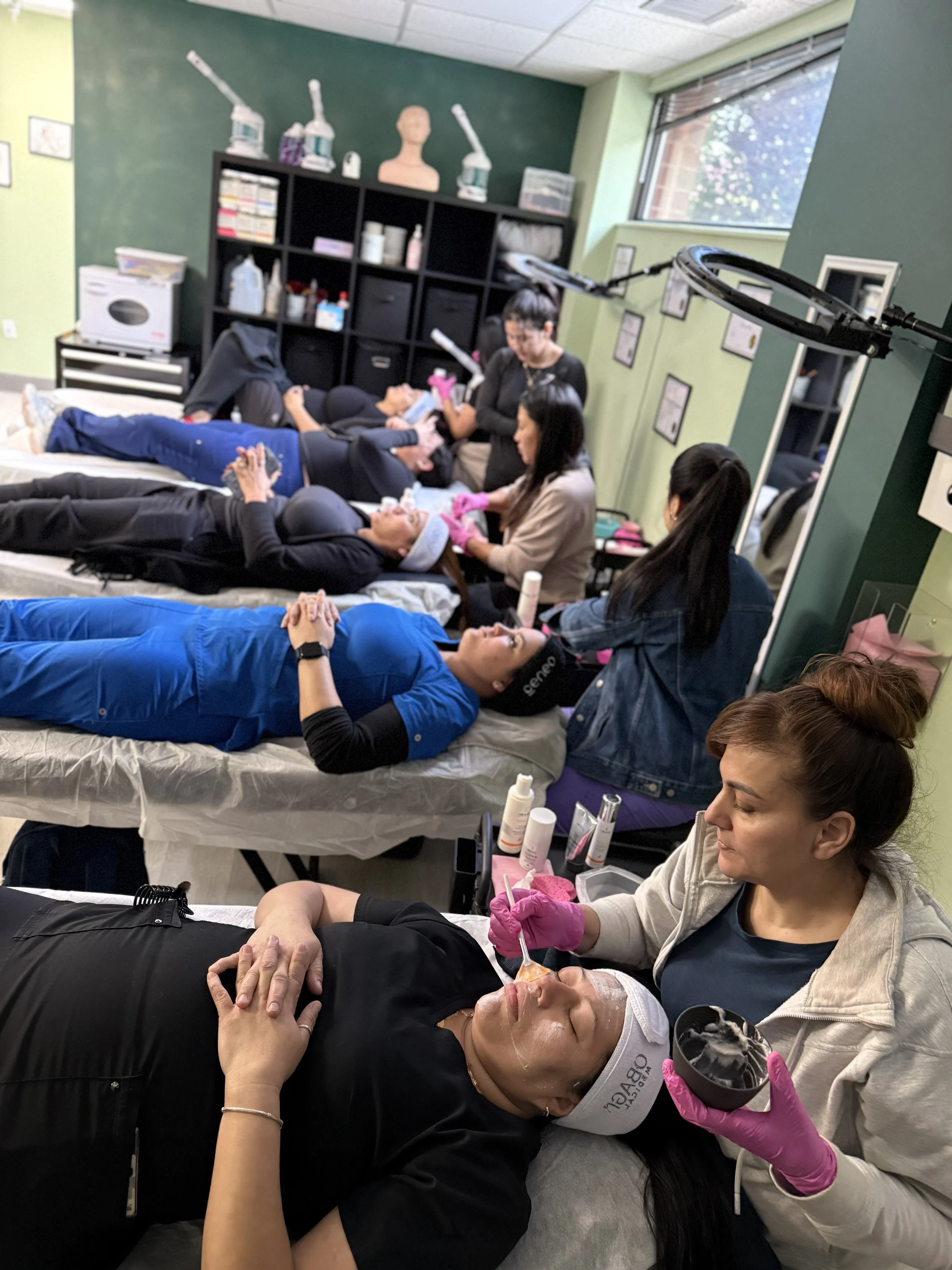 Esthetician students practicing skincare treatments in a classroom setting
