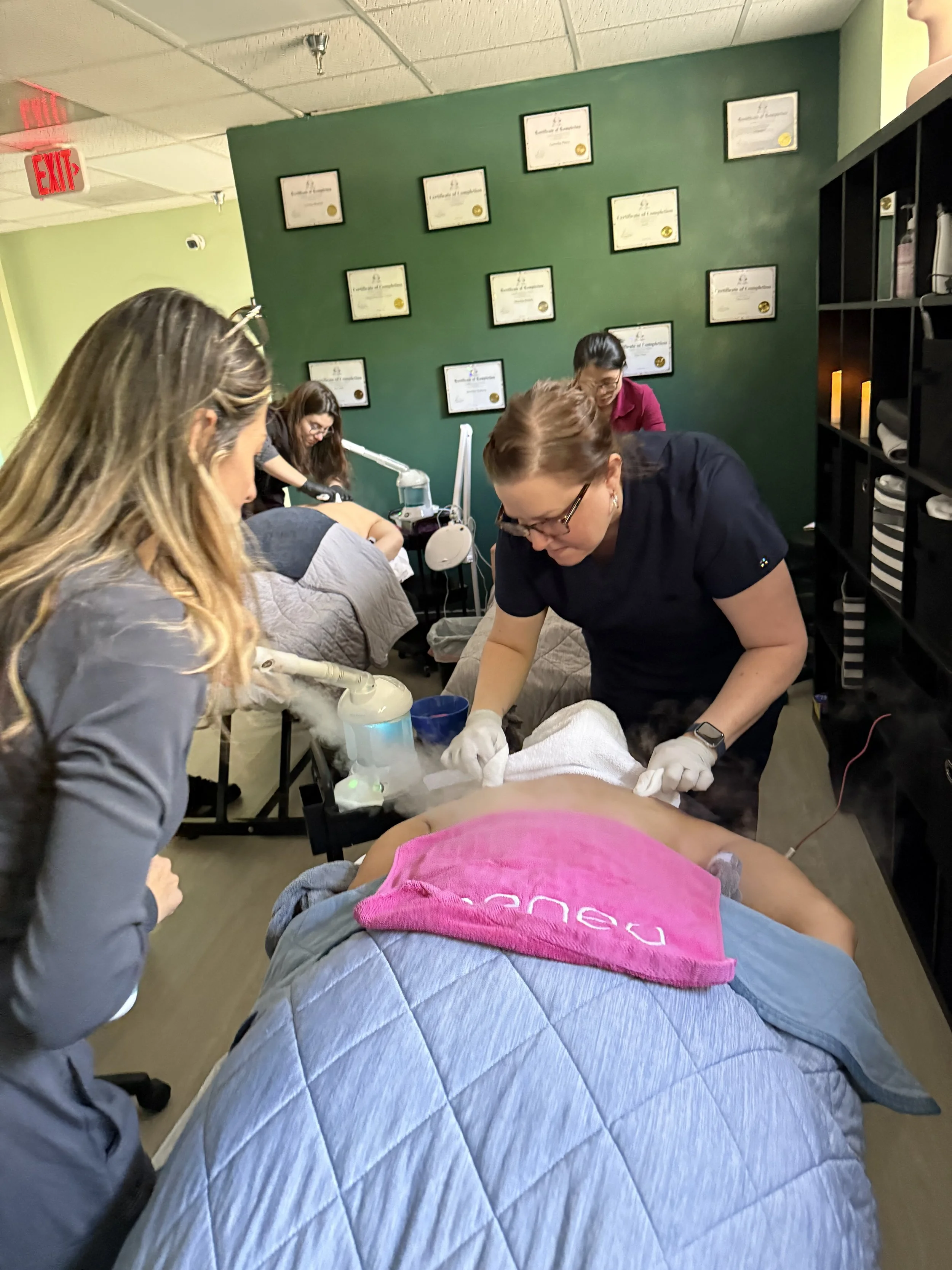Clase de estética con estudiantes practicando tratamientos faciales en un cliente
