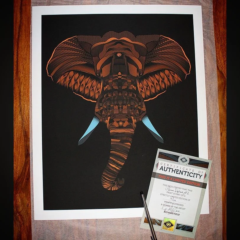 Digital artwork of an elephant with a butterfly-like wing pattern on a black background, framed with a white border, alongside a certificate of authenticity and a pen.