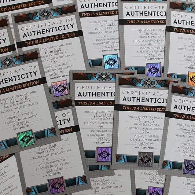 Collection of certificate of authenticity cards with colorful holographic stamps.
