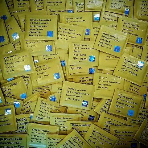 A collection of yellow envelopes with handwritten addresses and blue postage stamps, possibly mail or letters.