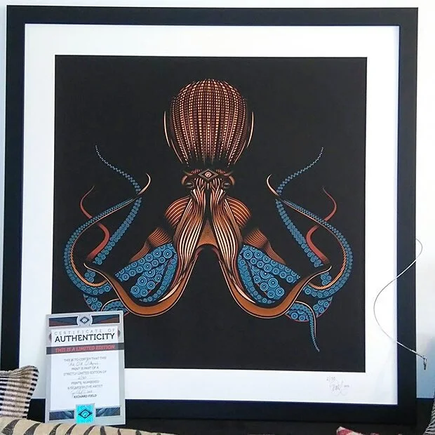 An abstract stylized illustration of a squid with intricate patterns in blue, red, and brown colors, set against a black background.
