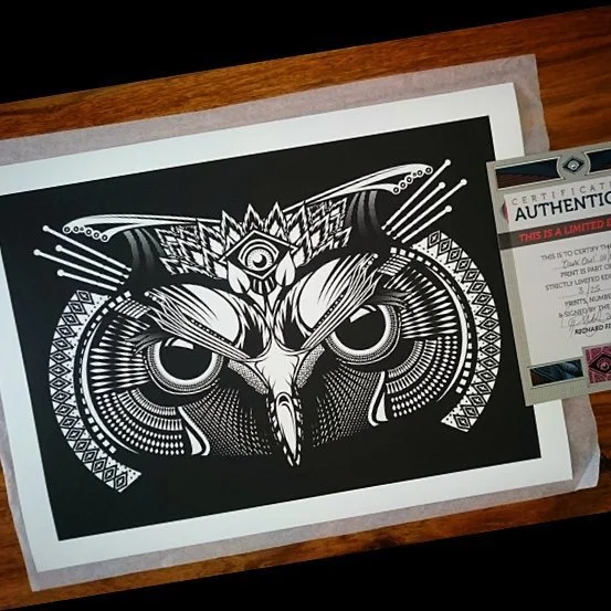 Black and white eye-catching owl illustration on paper with a certificate of authenticity beside it.