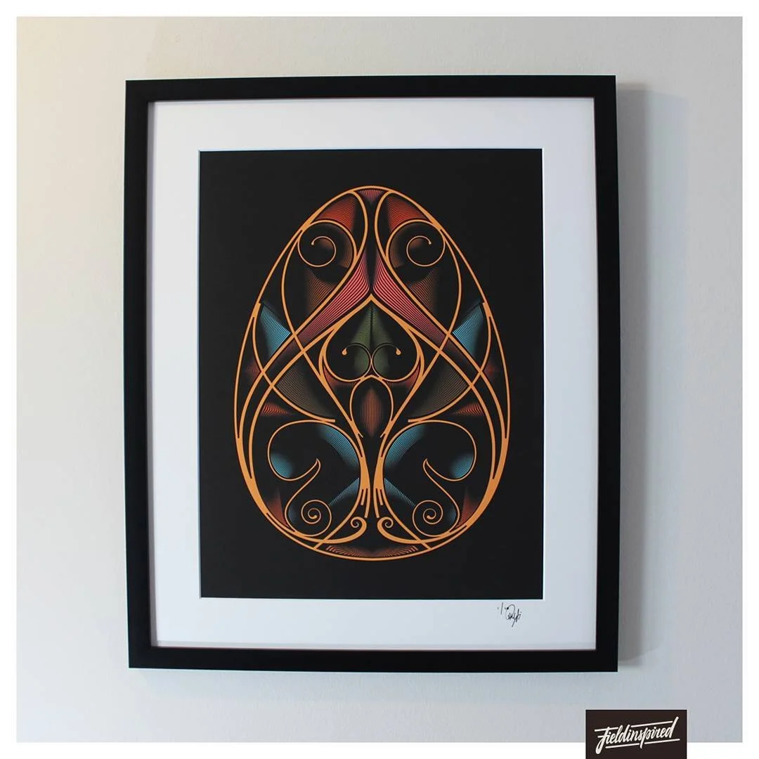 Abstract artwork of an oval shape with intricate swirl patterns in orange, pink, yellow, blue, and black on a black background, framed in black.